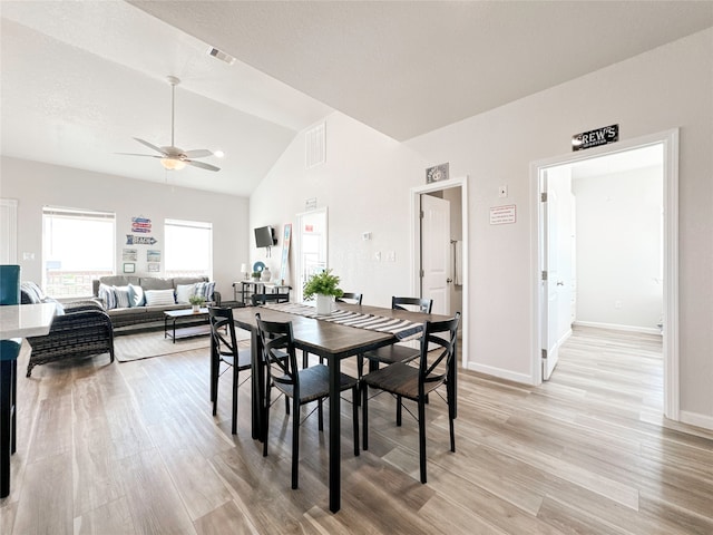 dining area with ceiling fan, a textured ceiling, light wood-type flooring, and vaulted ceiling