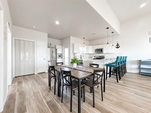 dining area with light hardwood / wood-style flooring and sink