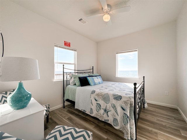 bedroom featuring multiple windows, ceiling fan, and dark hardwood / wood-style flooring