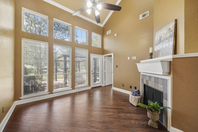 living room with ceiling fan, plenty of natural light, and dark wood-type flooring