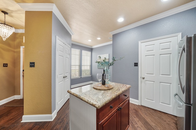 kitchen with hanging light fixtures, stainless steel refrigerator, dark hardwood / wood-style flooring, a textured ceiling, and ornamental molding