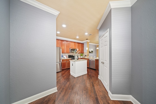 kitchen featuring hanging light fixtures, a kitchen island, stainless steel appliances, dark hardwood / wood-style flooring, and ornamental molding