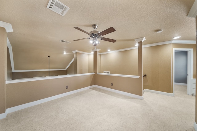 carpeted empty room with a textured ceiling, ceiling fan, and crown molding