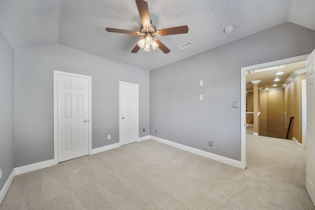 unfurnished bedroom featuring lofted ceiling, light carpet, and ceiling fan