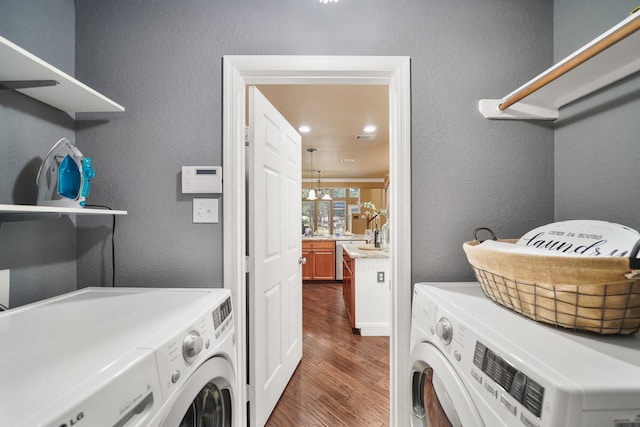 laundry room featuring an inviting chandelier, dark hardwood / wood-style floors, and independent washer and dryer