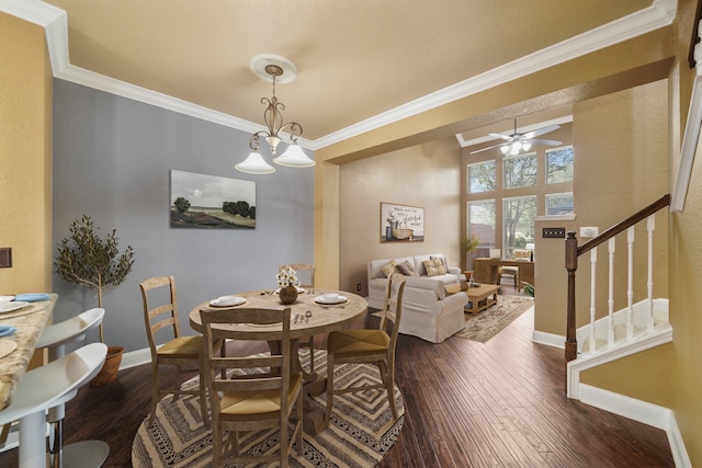 dining area featuring ceiling fan with notable chandelier, ornamental molding, and dark wood-type flooring