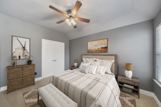 bedroom featuring ceiling fan, a closet, light carpet, and vaulted ceiling