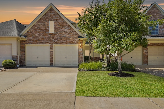 view of front of property with a garage and a yard