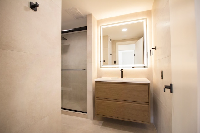 bathroom featuring vanity and a shower with door