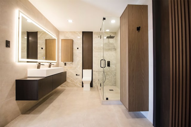 bathroom with vanity, walk in shower, toilet, and tile walls