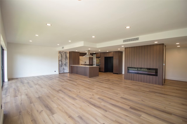 unfurnished living room featuring light hardwood / wood-style flooring and sink