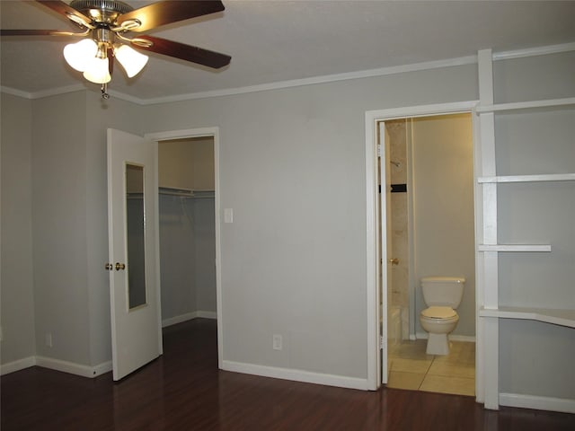 unfurnished bedroom featuring ceiling fan, a closet, crown molding, ensuite bathroom, and dark hardwood / wood-style flooring