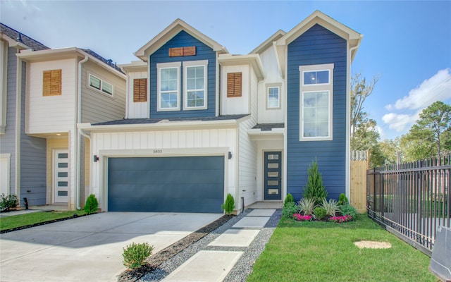 view of property featuring a garage and a front lawn