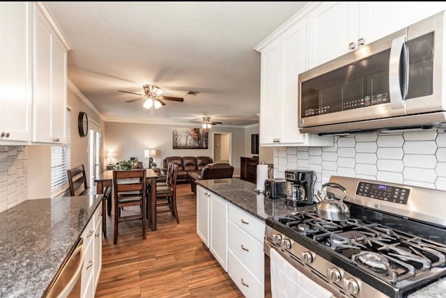 kitchen with crown molding, dark wood-type flooring, white cabinets, and stainless steel appliances