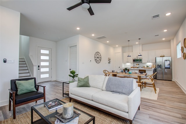 living room featuring light wood-type flooring and ceiling fan