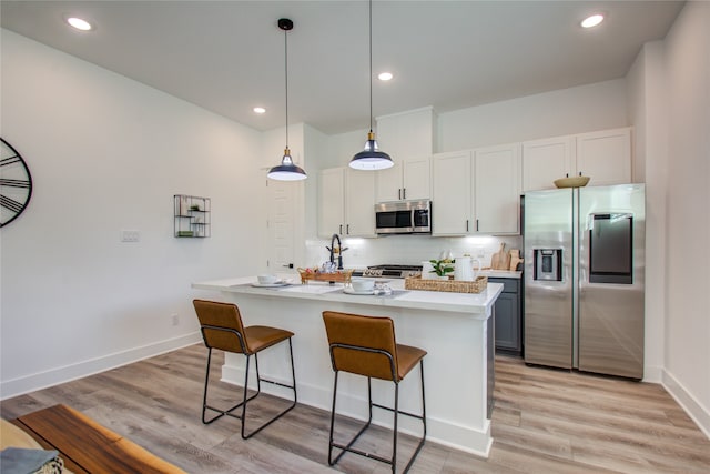 kitchen with light hardwood / wood-style flooring, a kitchen island with sink, stainless steel appliances, and white cabinetry