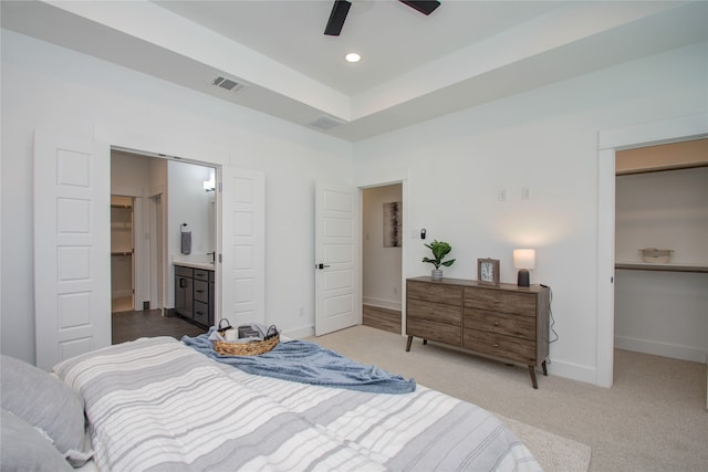 carpeted bedroom featuring ceiling fan and ensuite bath