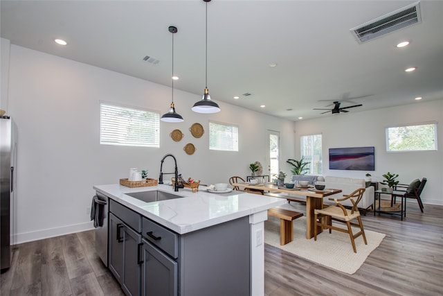 kitchen featuring a kitchen island with sink, sink, dark hardwood / wood-style flooring, and plenty of natural light