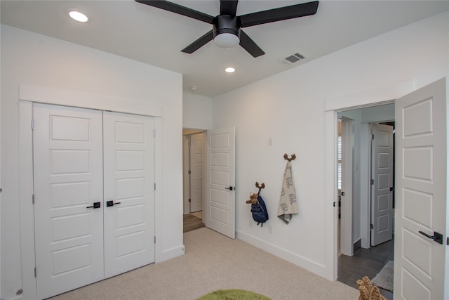 carpeted bedroom with a closet and ceiling fan