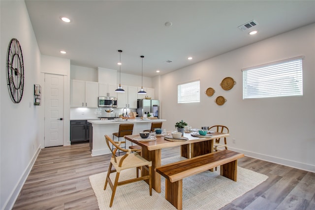 dining area featuring sink and light hardwood / wood-style flooring