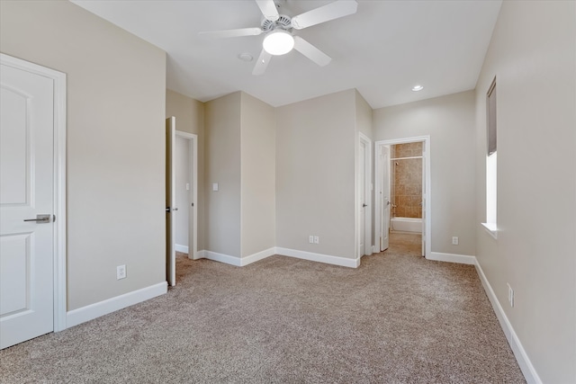 unfurnished bedroom with ceiling fan, light colored carpet, and connected bathroom