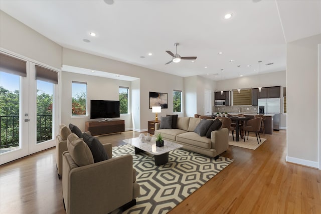 living room featuring ceiling fan and light hardwood / wood-style flooring