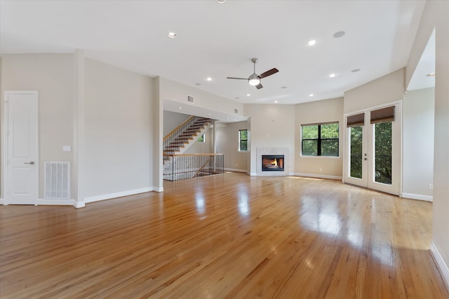 unfurnished living room featuring ceiling fan, light hardwood / wood-style floors, and french doors