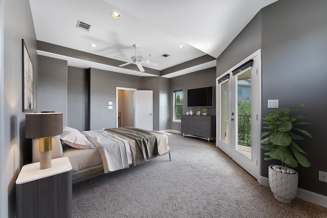 carpeted bedroom featuring access to outside, a raised ceiling, and ceiling fan