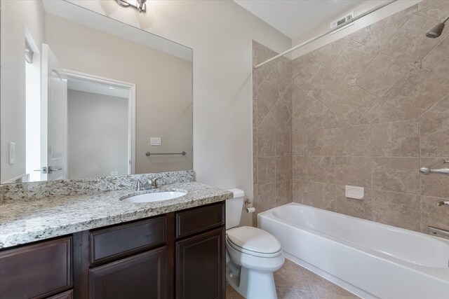 full bathroom featuring vanity, tile patterned floors, tiled shower / bath combo, and toilet