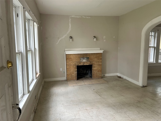 unfurnished living room featuring a brick fireplace