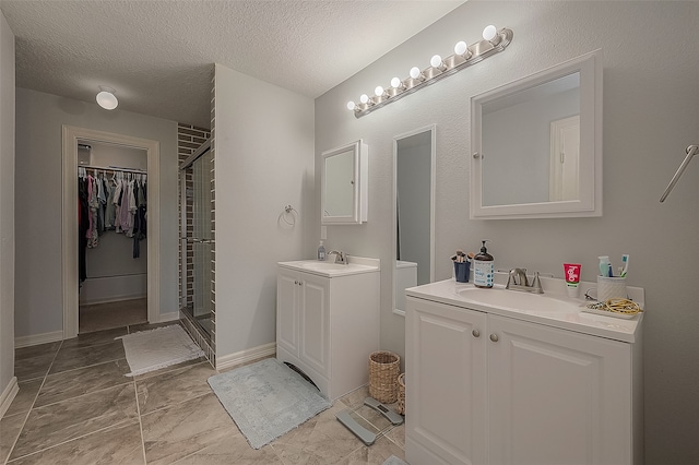 bathroom featuring a textured ceiling, vanity, and a shower with door