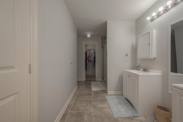 bathroom with vanity, a textured ceiling, and an enclosed shower