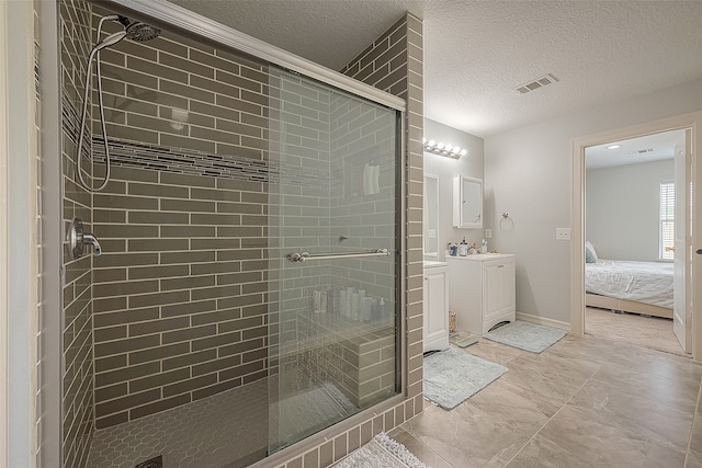 bathroom with a textured ceiling, vanity, and an enclosed shower