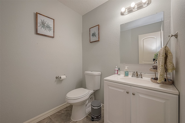 bathroom featuring a textured ceiling, vanity, and toilet