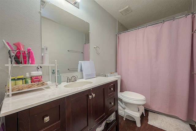 bathroom with curtained shower, vanity, a textured ceiling, hardwood / wood-style flooring, and toilet