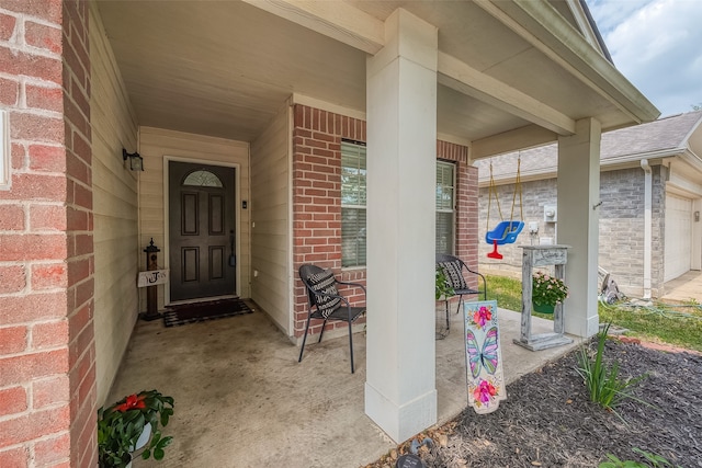 entrance to property with covered porch and a garage