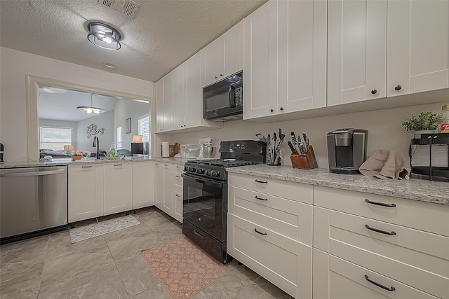 kitchen with light stone counters, white cabinets, sink, a textured ceiling, and black appliances