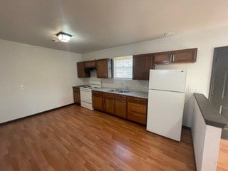 kitchen with white appliances, sink, and hardwood / wood-style flooring