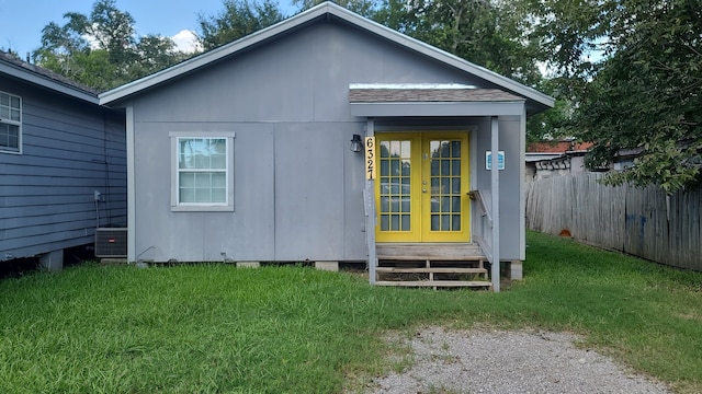 rear view of property with a lawn and french doors