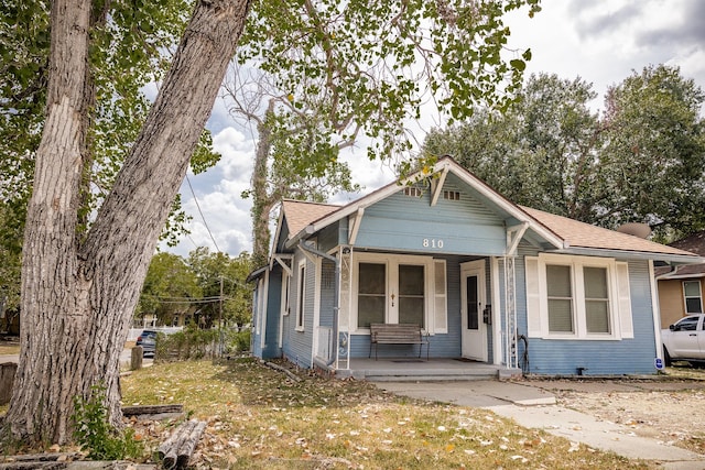 bungalow-style home featuring a porch and a shingled roof