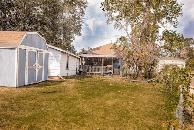 view of yard with covered porch, an outdoor structure, and a storage shed