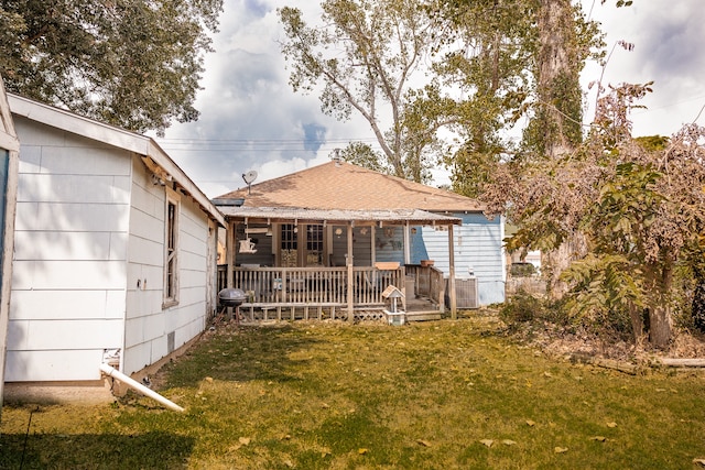 rear view of house featuring a wooden deck and a yard