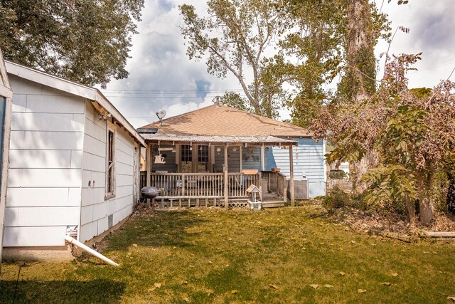 rear view of house featuring a lawn