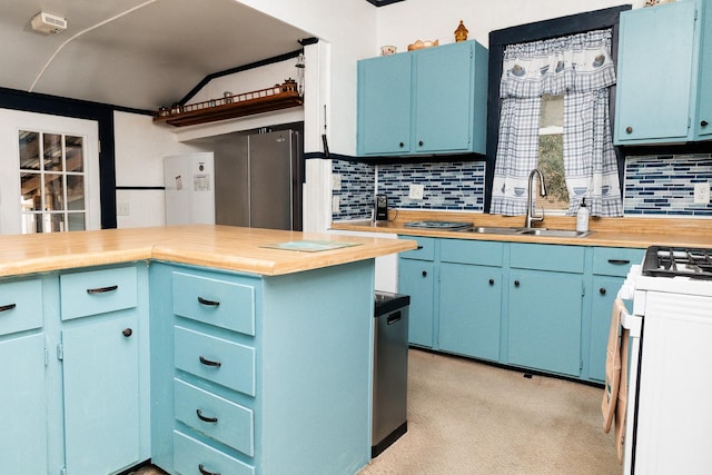 kitchen featuring blue cabinets, white gas range oven, a sink, and tasteful backsplash