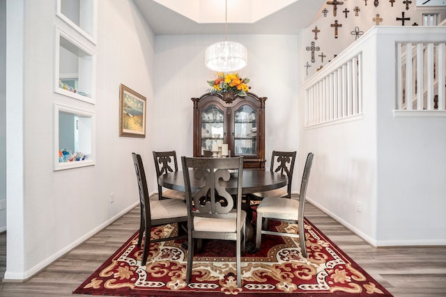 dining room featuring a chandelier, wood-type flooring, and a high ceiling