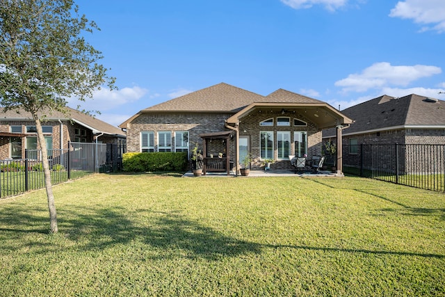 rear view of house featuring a lawn and a patio area