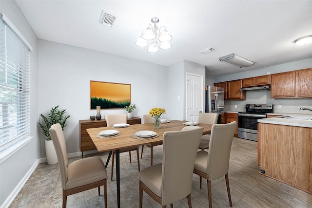 dining space featuring an inviting chandelier and sink