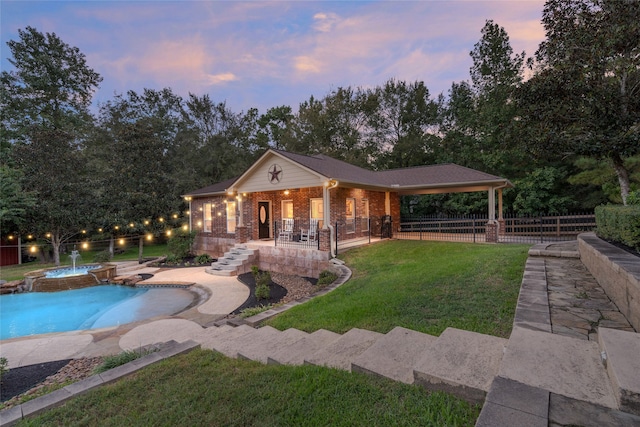 pool at dusk featuring a yard, pool water feature, and a patio area