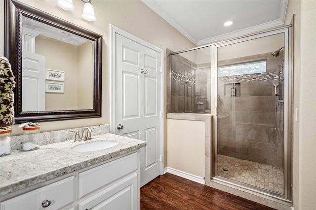 bathroom featuring wood-type flooring, vanity, crown molding, and walk in shower