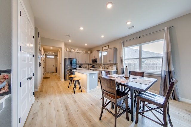 dining space with sink and light hardwood / wood-style flooring